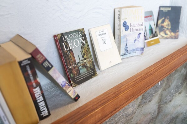 Una hilera de libros en una estantería contra una pared.