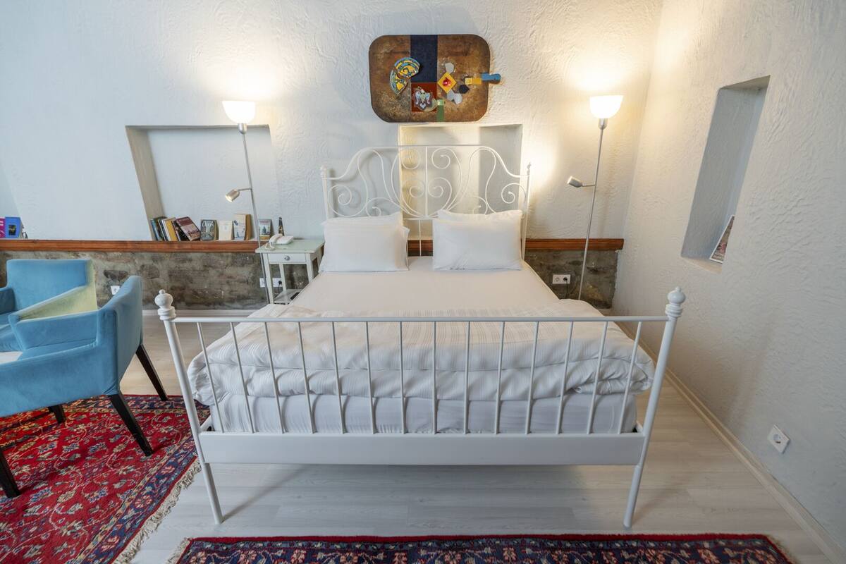 A neatly arranged bedroom with a bed, a chair, and a desk.