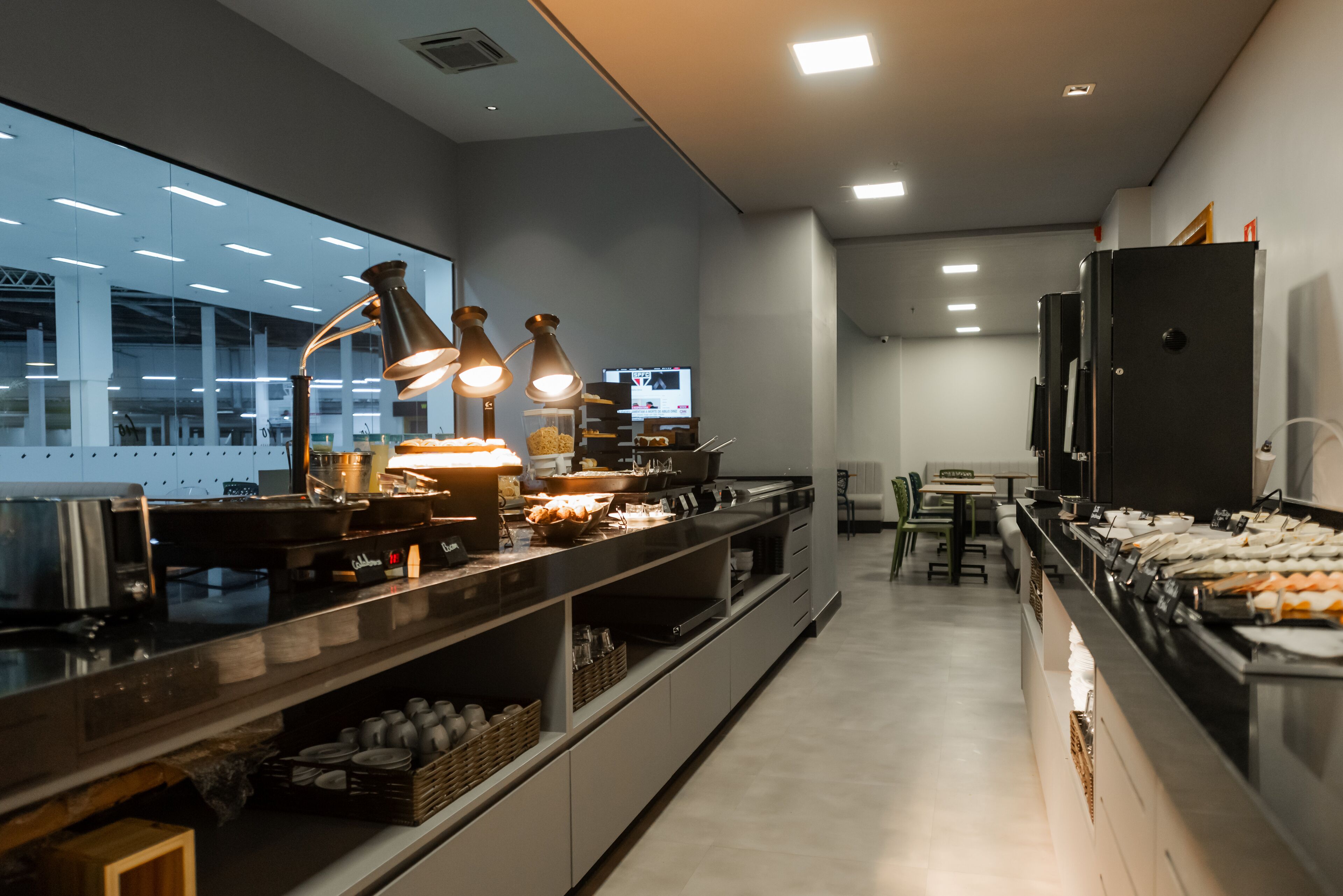 A modern kitchen with stainless steel appliances, a long counter, and overhead lighting.