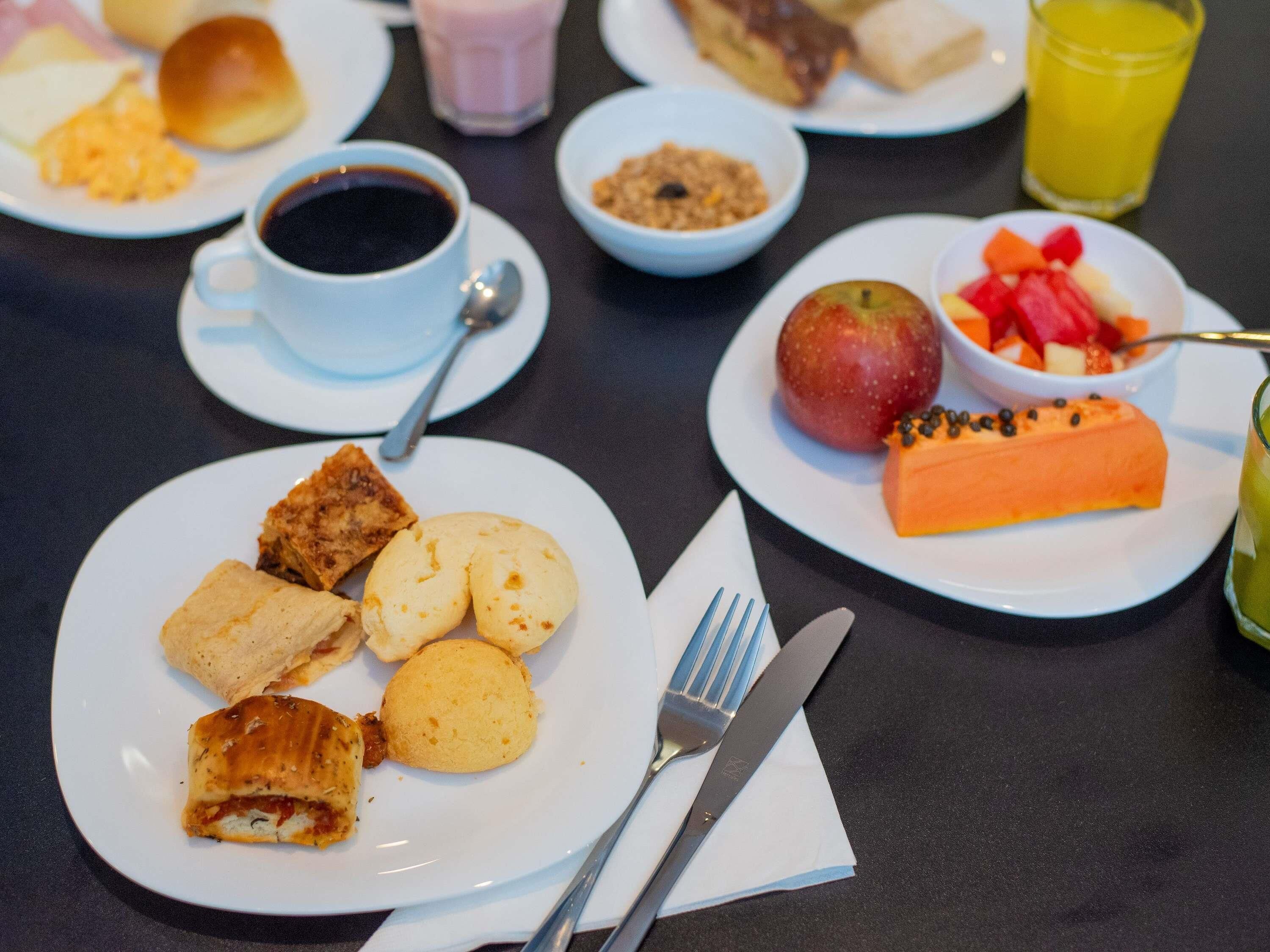 Desayuno con platos de comida, una taza de café y un vaso de jugo.