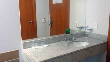 Casa de banho com duas pias, um espelho e frigorífico.