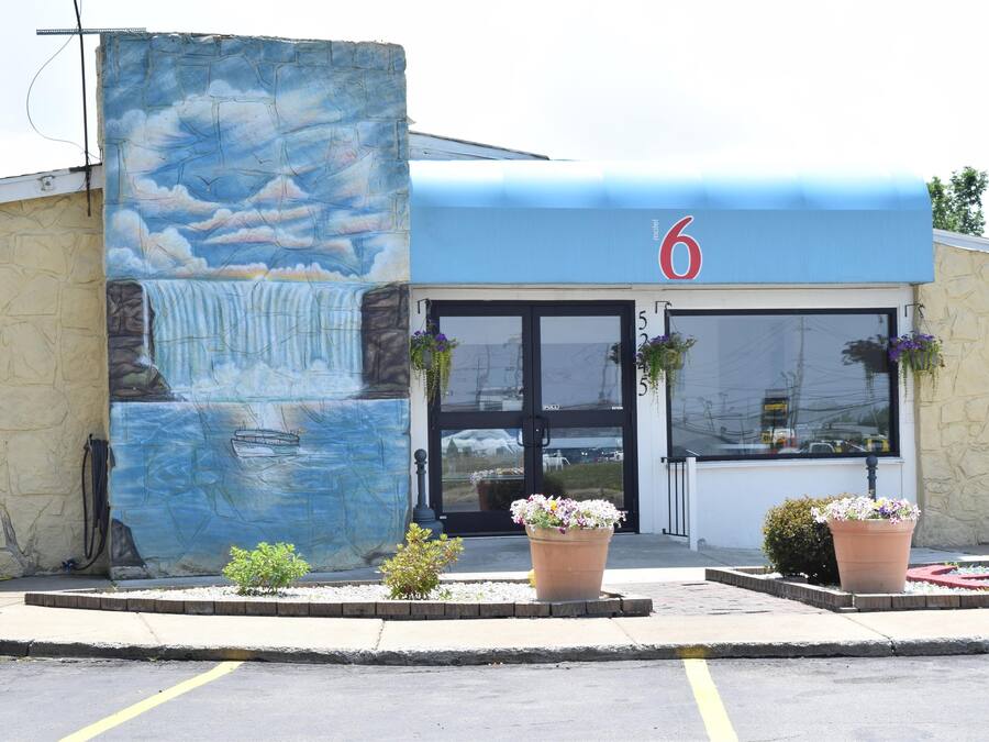 A motel with a mural of a waterfall and a number '6' sign above the entrance.