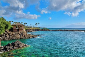 A coastal property with a single-story building, a rocky shoreline, and clear blue waters. - The Resort at Kapalua Bay, Maui (Lahaina)