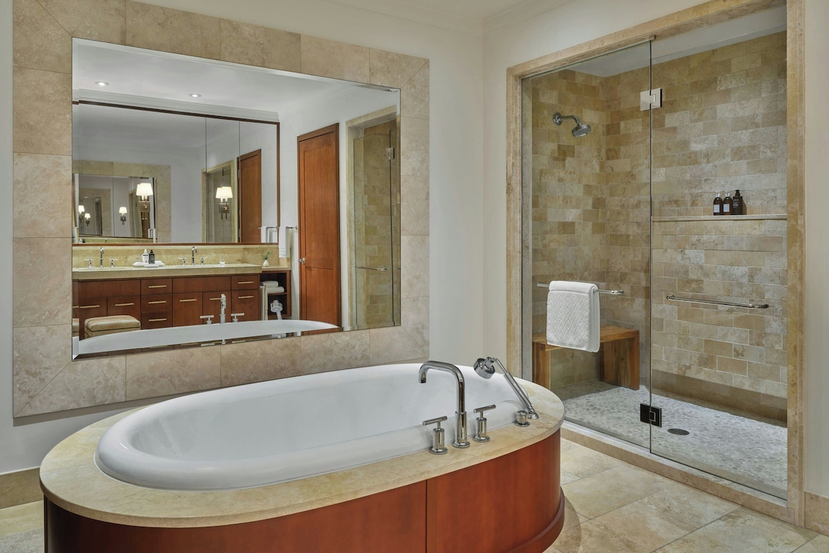 A modern bathroom with a freestanding bathtub, a glass-enclosed shower, and a large mirror.