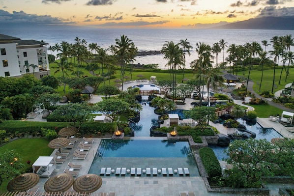 A resort with a swimming pool, lounge areas, and a view of the ocean. - The Resort at Kapalua Bay, Maui (Lahaina)