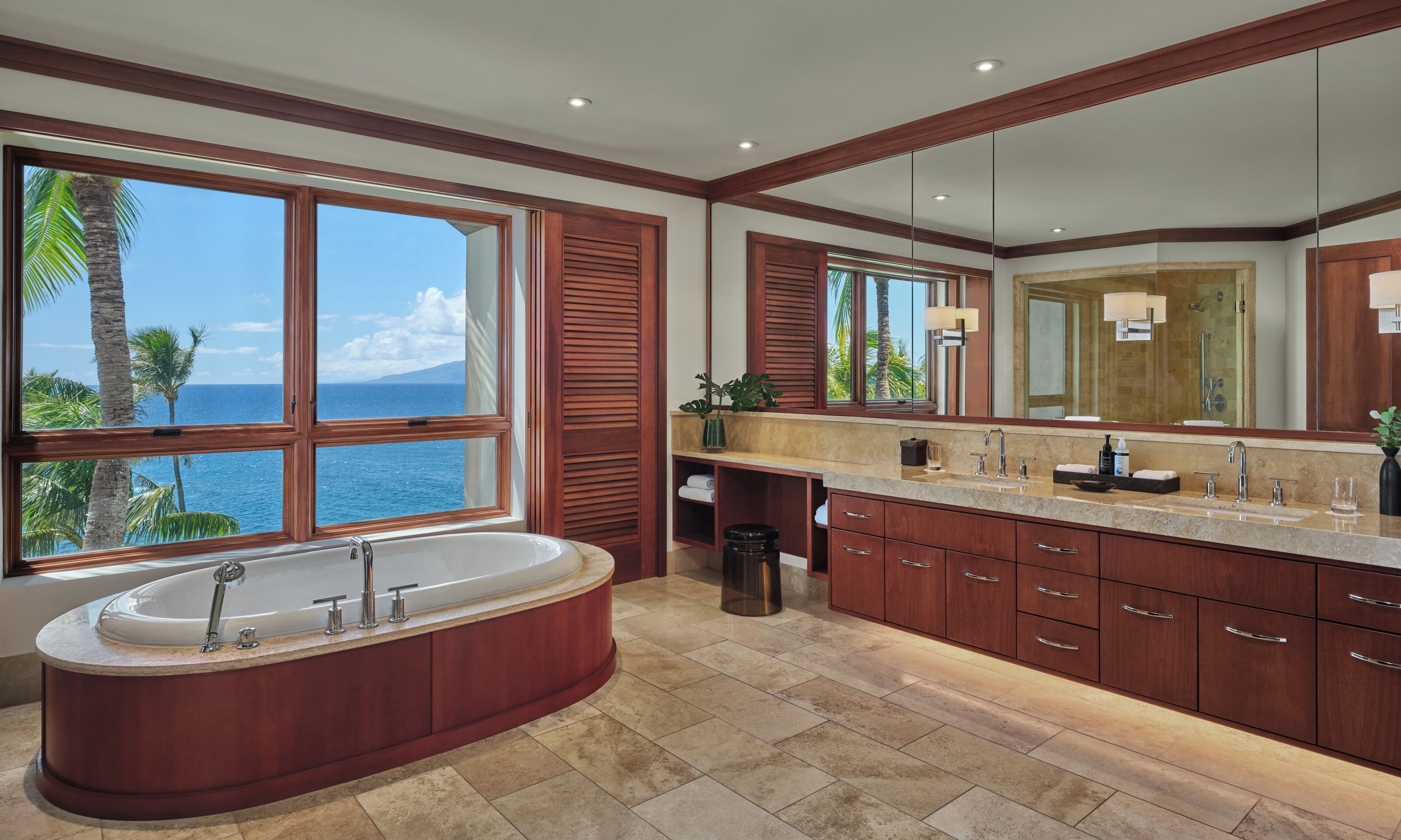 A modern bathroom with a large bathtub, a vanity with a sink, and a large mirror.