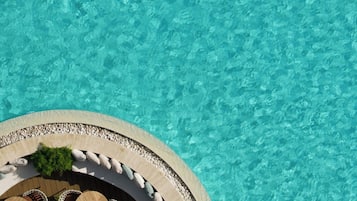 Een buitenzwembad, parasols voor strand/zwembad