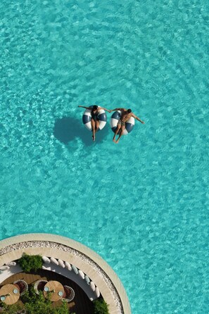 Una piscina al aire libre, sombrillas, tumbonas