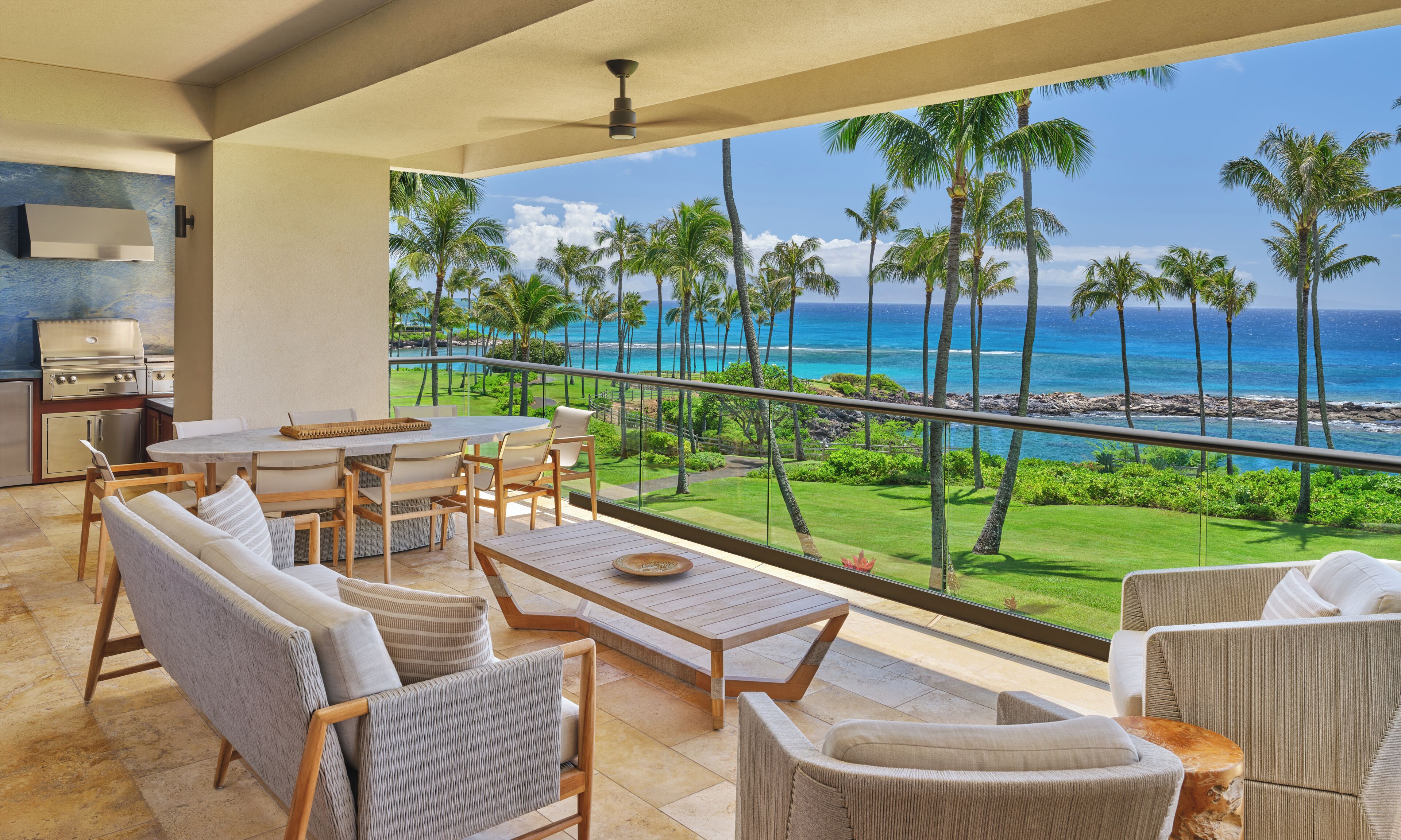 Un balcon avec vue sur l’océan, un barbecue et du mobilier d’extérieur.