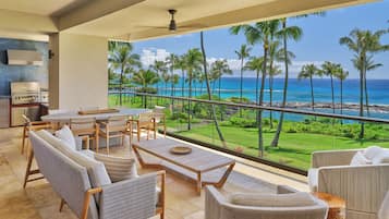 Un balcon avec vue sur l’océan, un barbecue et du mobilier d’extérieur.