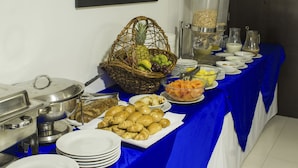 A buffet setup with various food items, including fruits, pastries, and beverages. - Hotel Innova Chipichape (Cali)