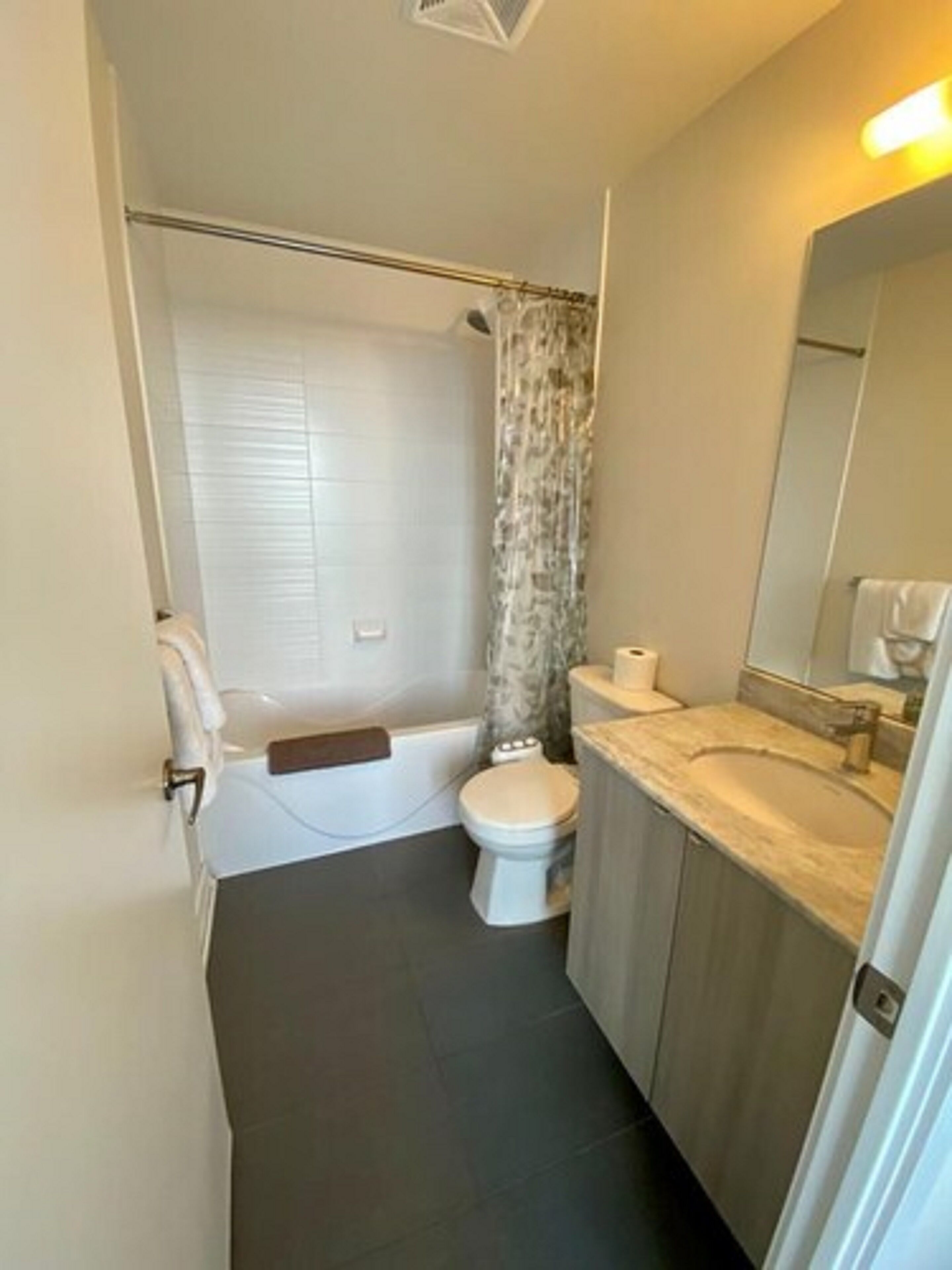 Un baño pequeño con bañera, inodoro y lavabo.