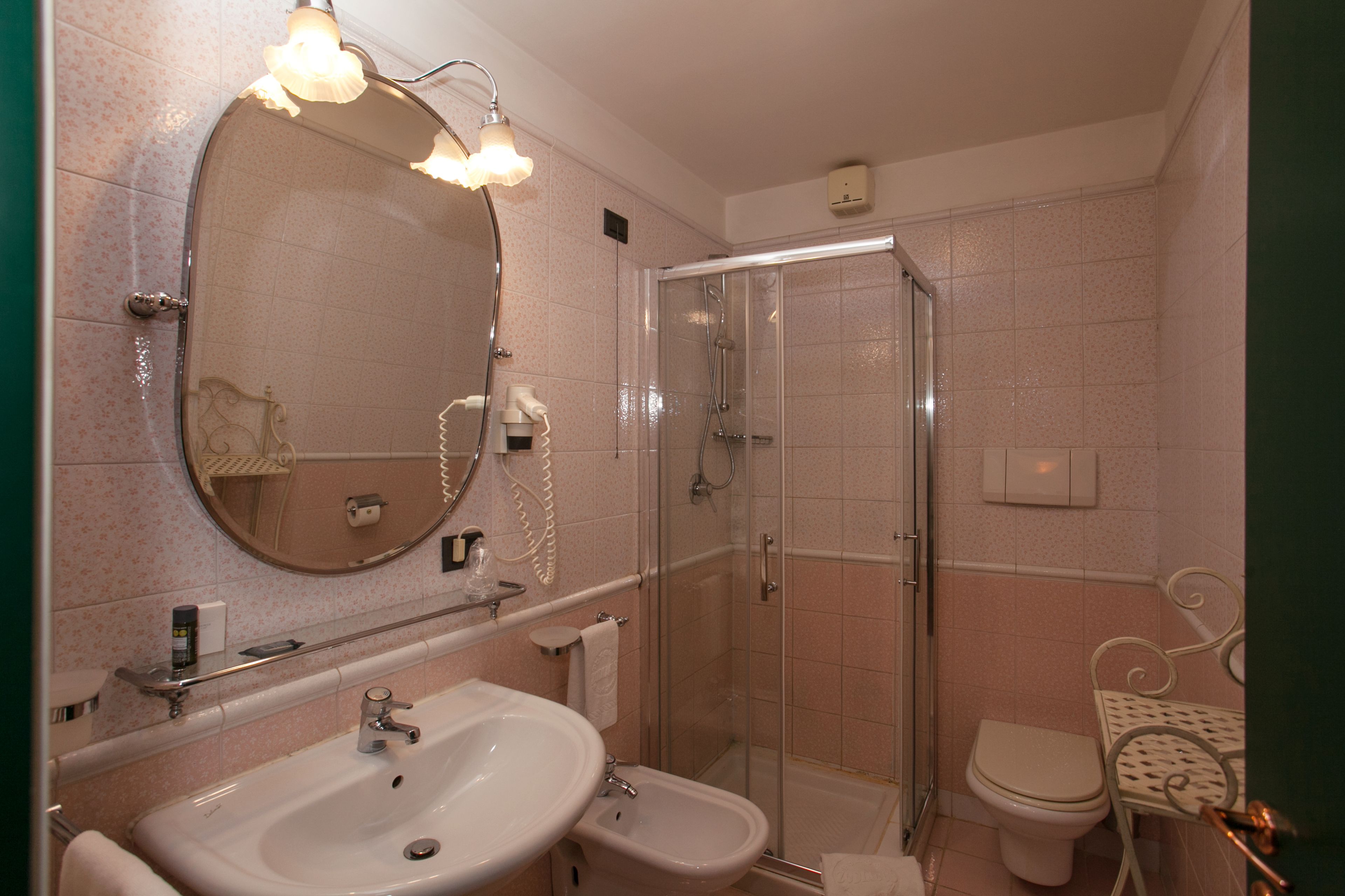 Une salle de bain équipée d’un lavabo, d’un bidet, de toilettes et d’une douche à parois de verre.