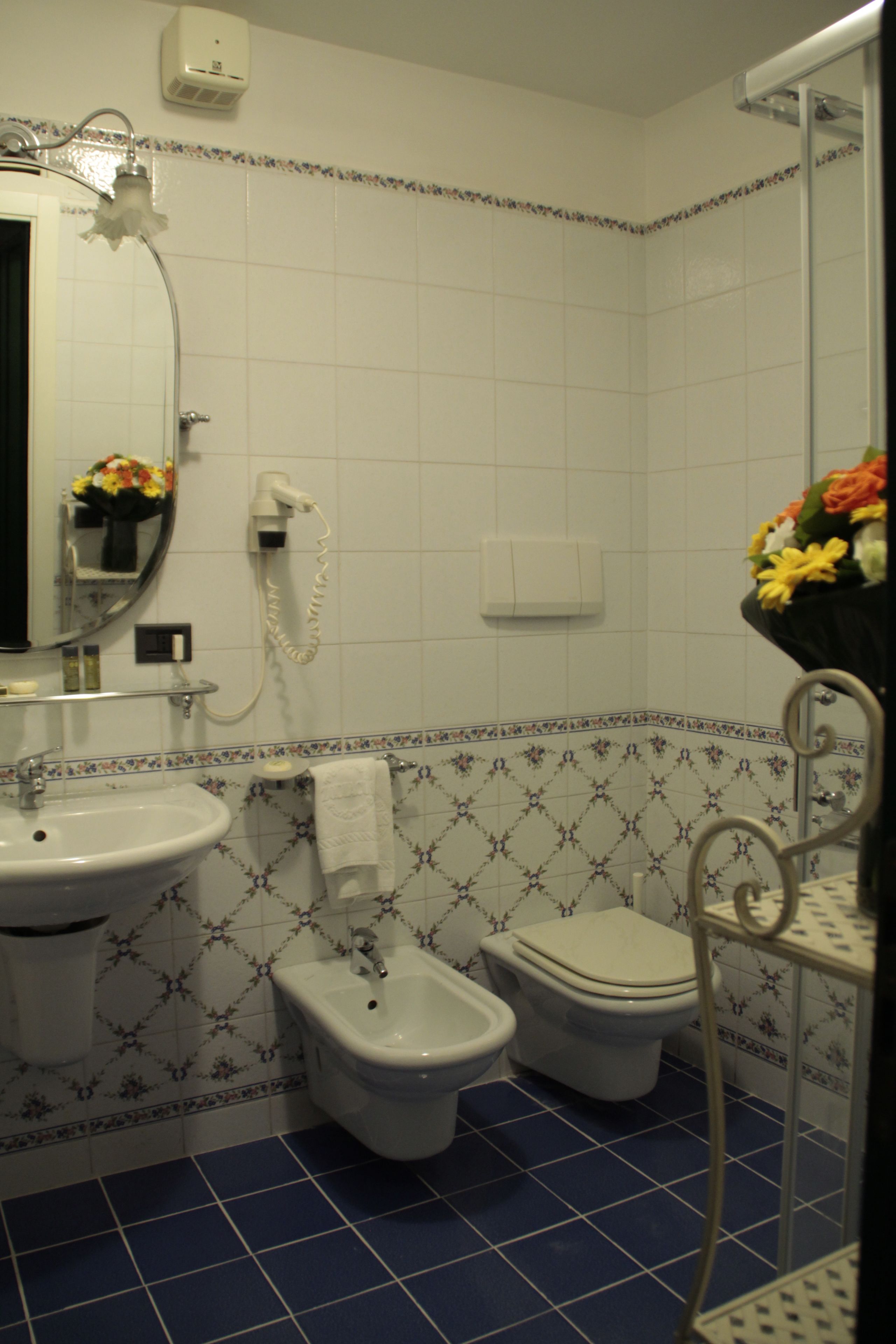 Un baño con lavamanos, bidé, inodoro y zona de ducha.