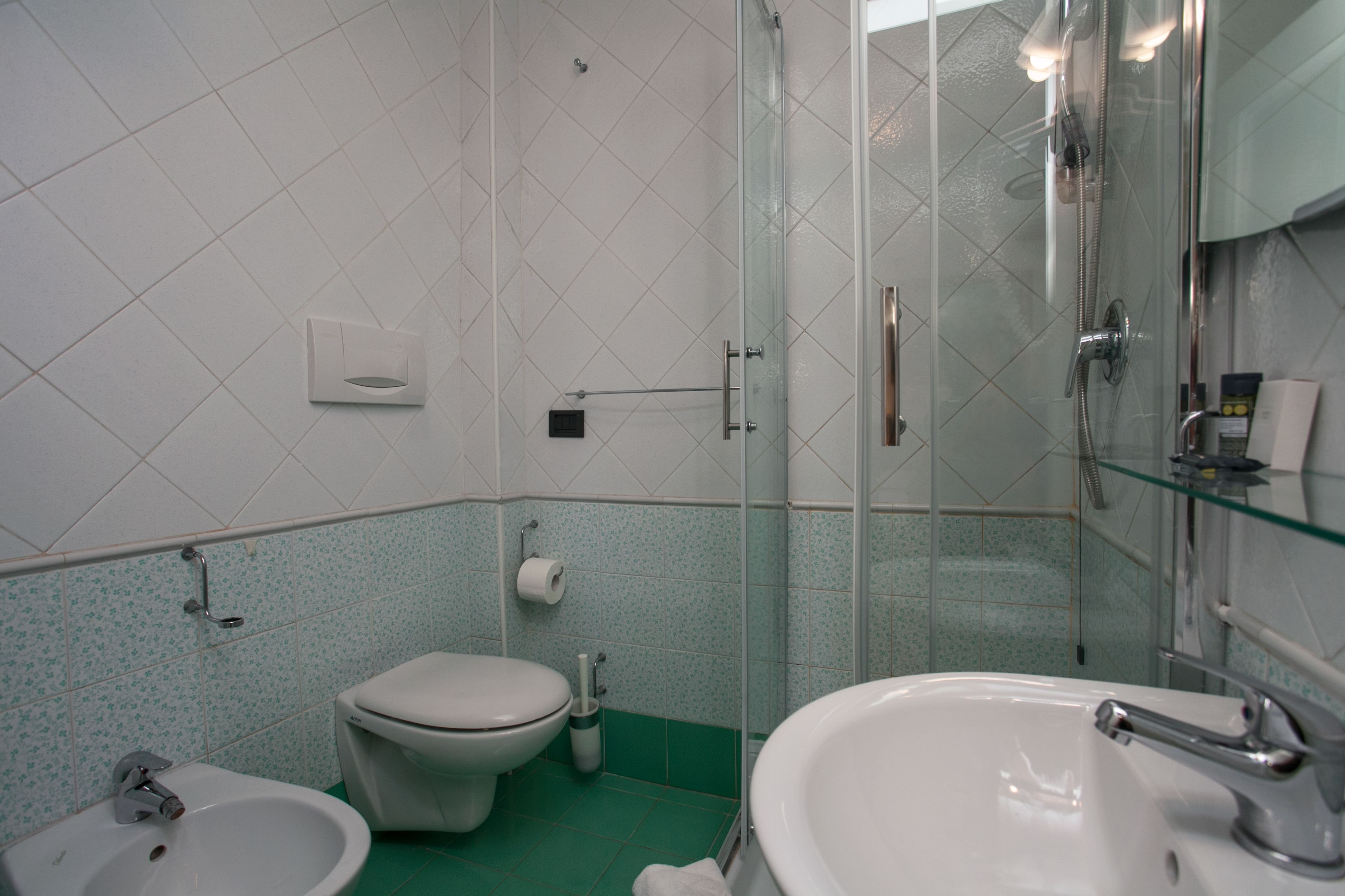 A bathroom with a toilet, bidet, and sink.