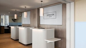Un espace d’accueil au design moderne, comprenant un comptoir d’accueil, une enseigne encadrée portant l’inscription « LONDON EUSTON » et un plancher en bois.