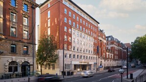 Un hôtel à plusieurs étages, de style architectural classique, qui se distingue par un grand panneau « Four Points Flex » placé au niveau du rez-de-chaussée.