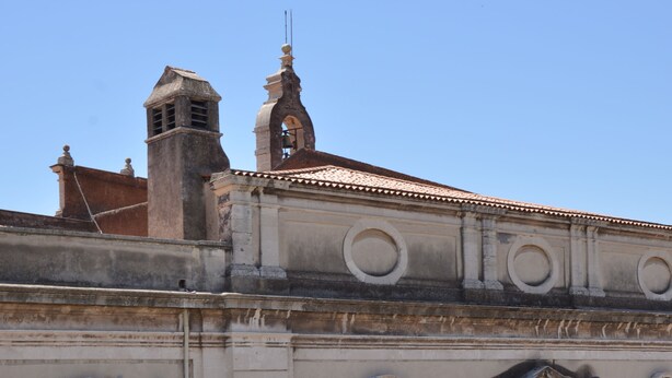 A building with classical architecture, including arched windows and a bell tower. - Al Teatro Massimo Home (Catania)