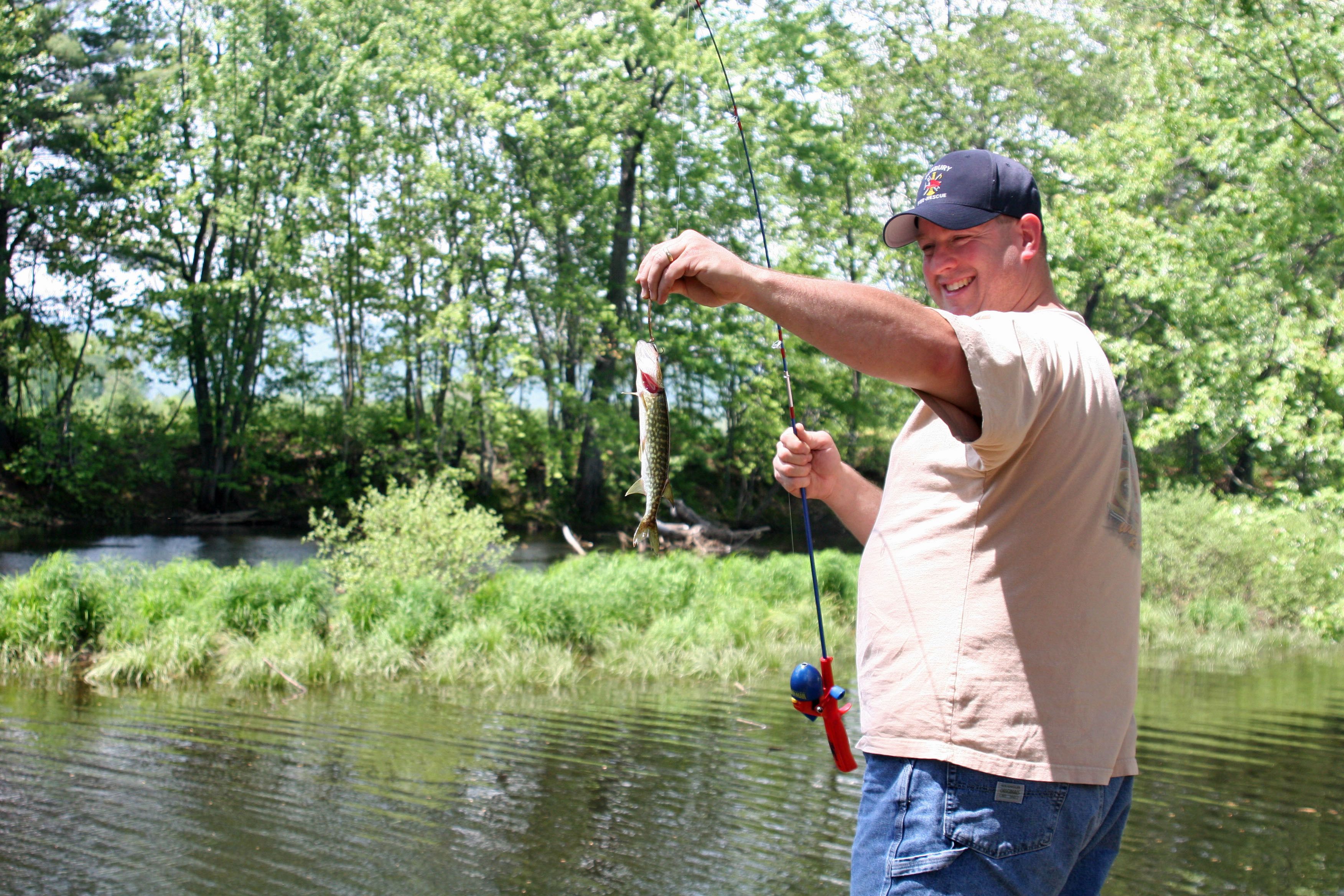 A person holding a fish with a fishing rod.