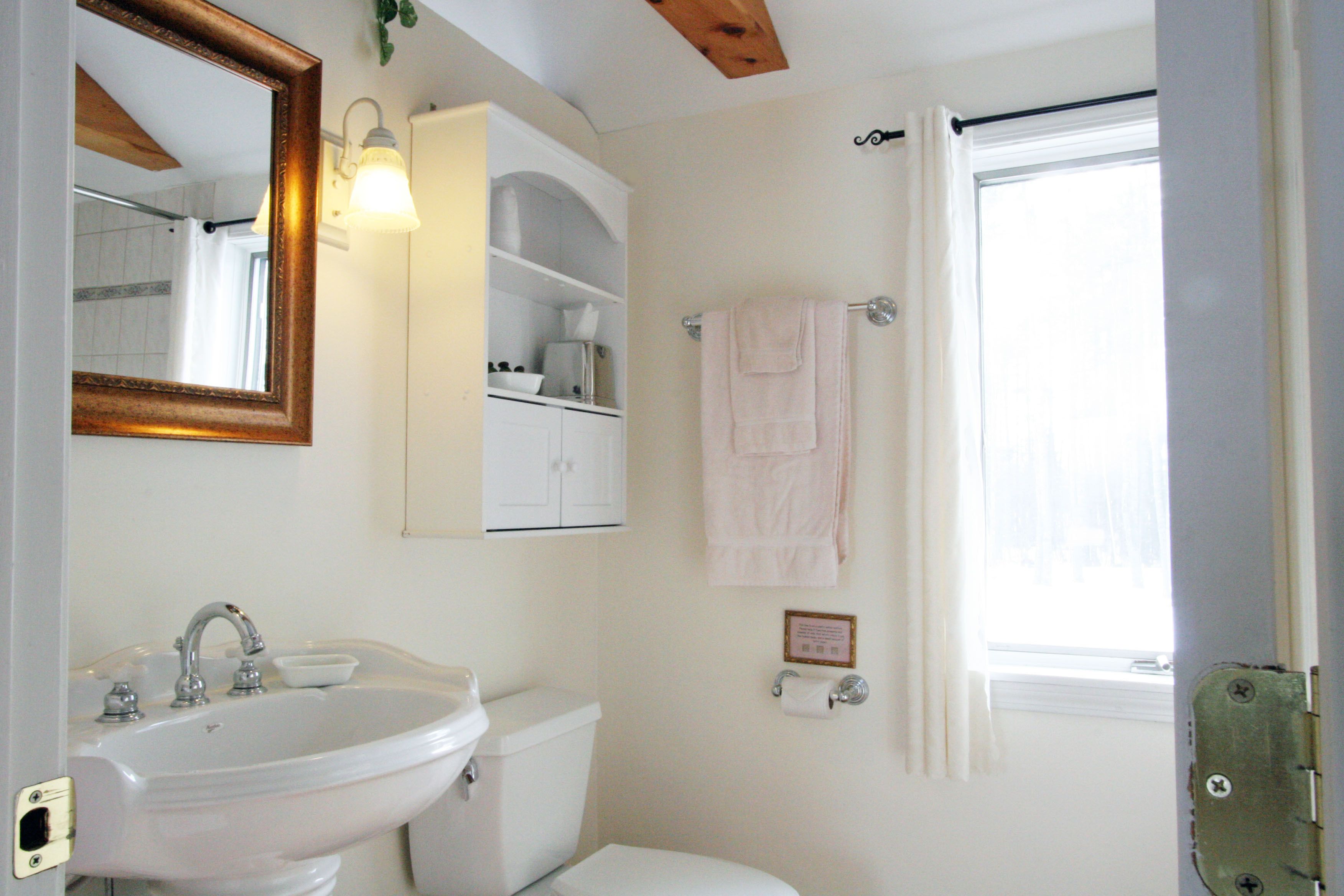Une salle de bain avec un lavabo, des toilettes et un miroir.