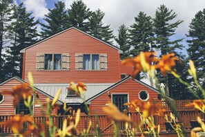 A red wooden house with a gabled roof and a front porch.