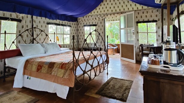 A bedroom with a bed, a desk, and a window. - Grassroots Wayanad, Valley-view Tents (Vythiri)