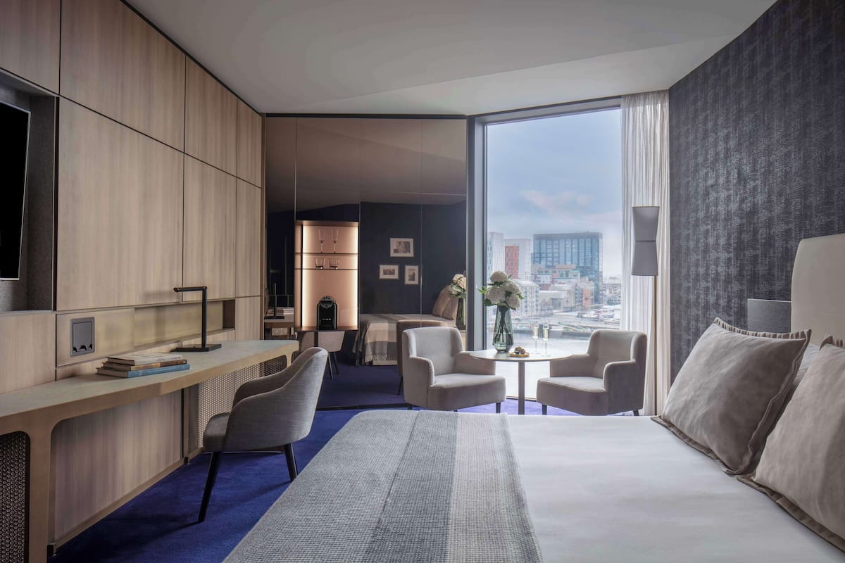 Un hotel moderno con una cama grande, un escritorio y vistas a la ciudad.