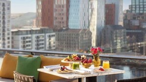 Una mesa de comedor con alimentos para el desayuno y vistas a la ciudad.