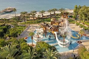 Un parc aquatique avec des toboggans, une piscine et des palmiers.