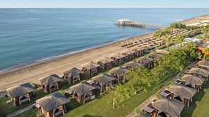 Bãi biển riêng, nhà lều trên biển, ghế dài tắm nắng, dù trên bãi biển 