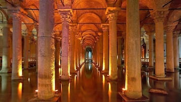 A corridor with columns and arches, leading to a central point.