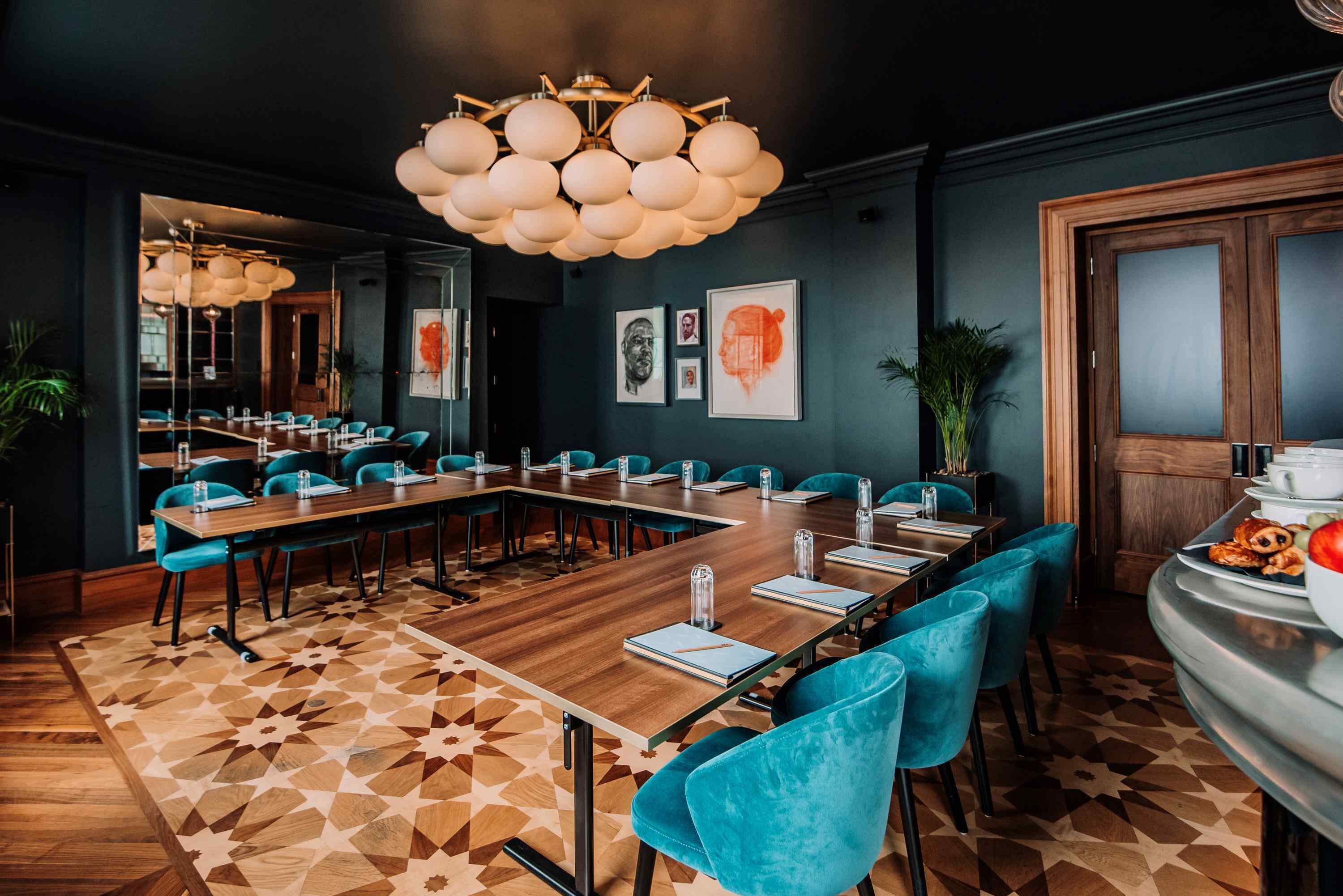 A conference room with a long table, blue chairs, and a geometric patterned floor.