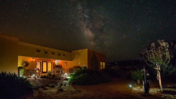 A house with a warm exterior and a starry night sky.