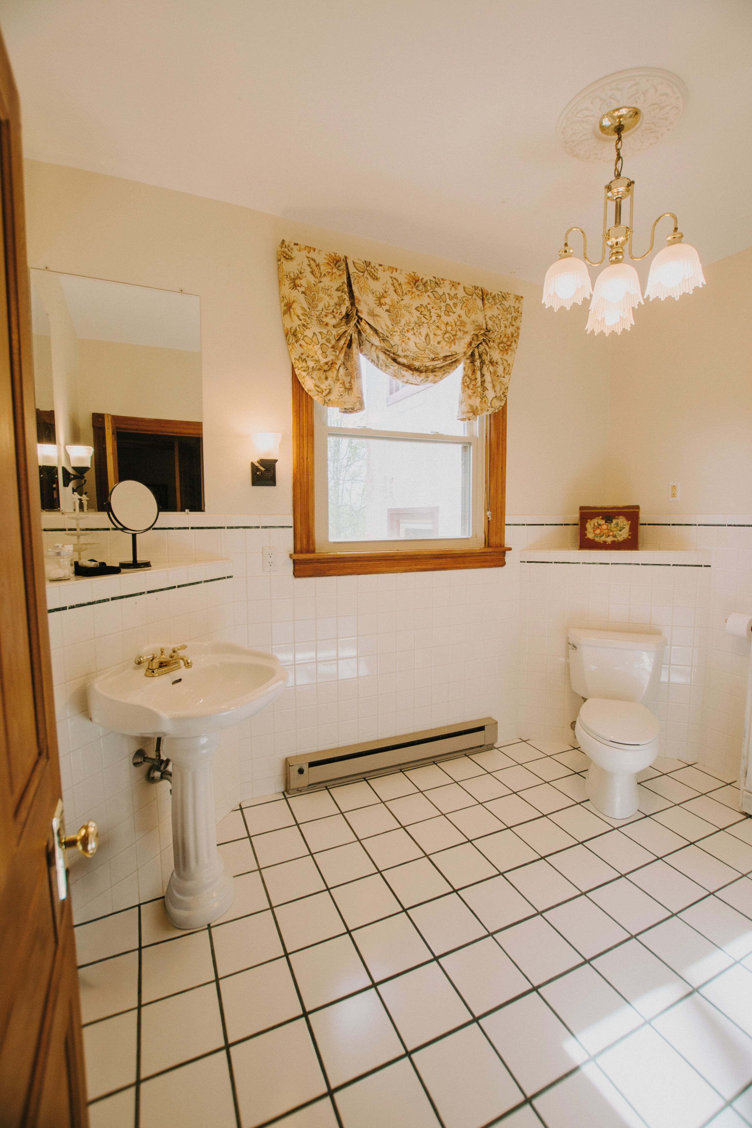 A bathroom with a sink, toilet, and mirror.