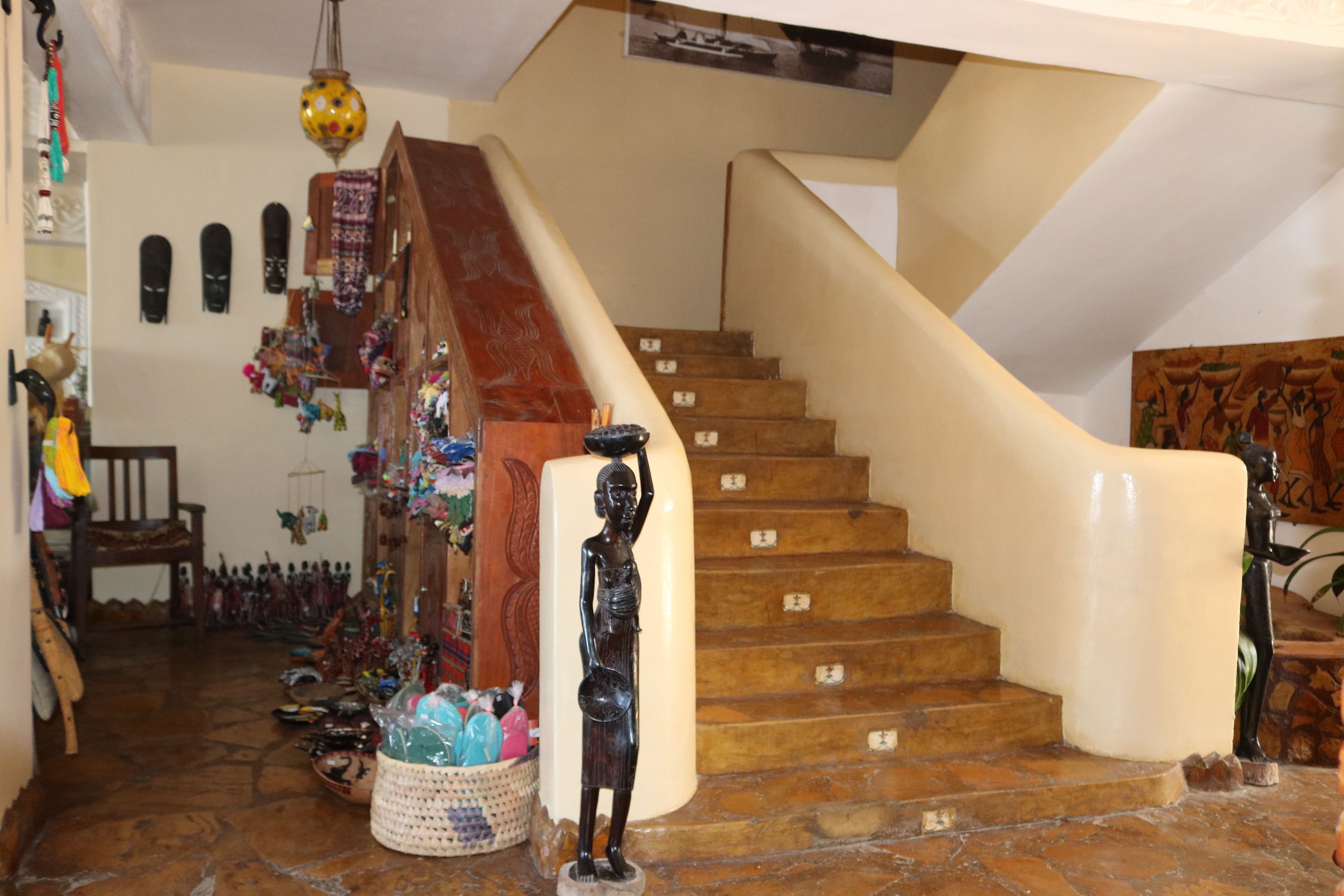 Una escalera con barandilla de madera y paredes color crema.