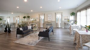 A spacious living room with a sofa, armchairs, a coffee table, and a dining area with a table and chairs. - Prairie Guest House (Fishers)