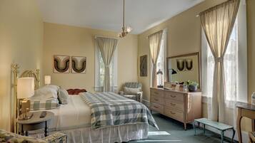 A bedroom with a bed, bedside tables, a dresser, a chair, and a bench.