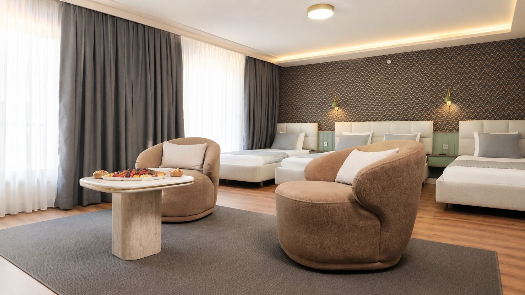 A modern hotel room with a sofa set, a round table with a plate of food, and a patterned wall.
