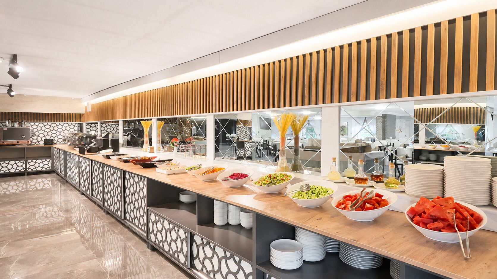 A buffet setup with various food items and stacked plates.