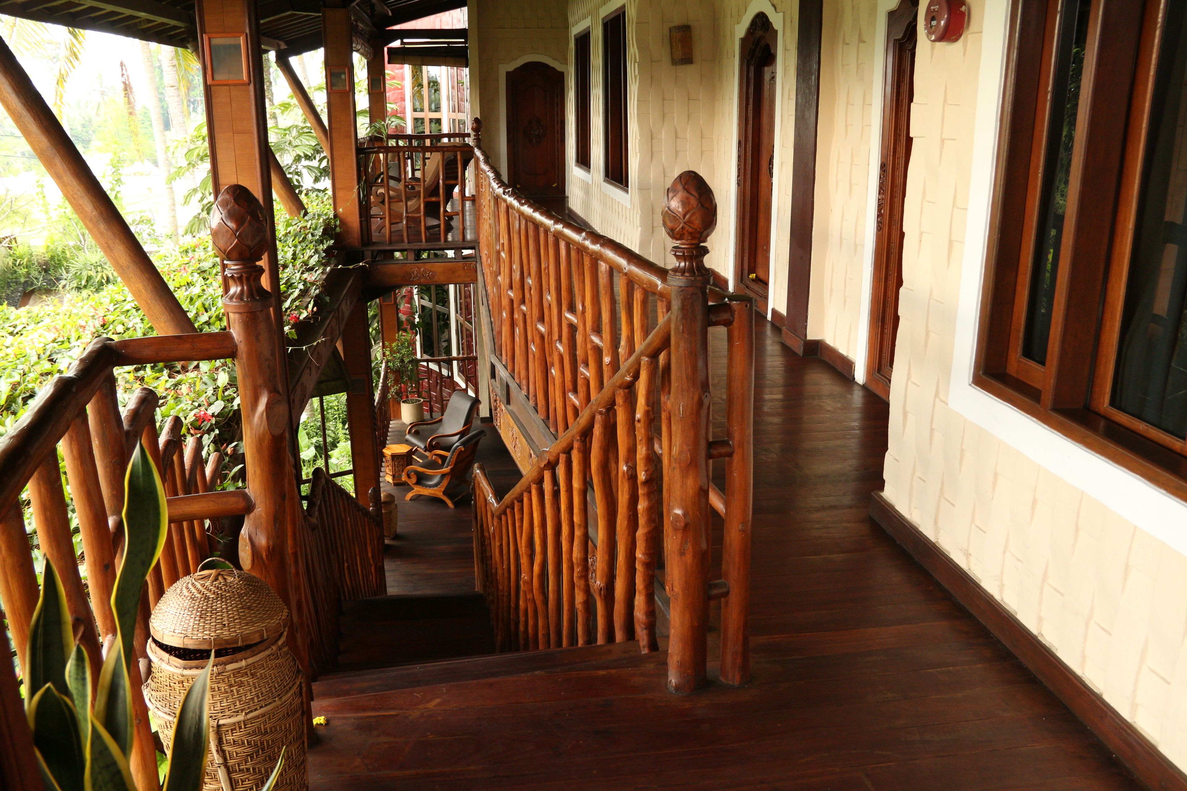 A wooden staircase with a balustrade leading to a second-floor balcony.