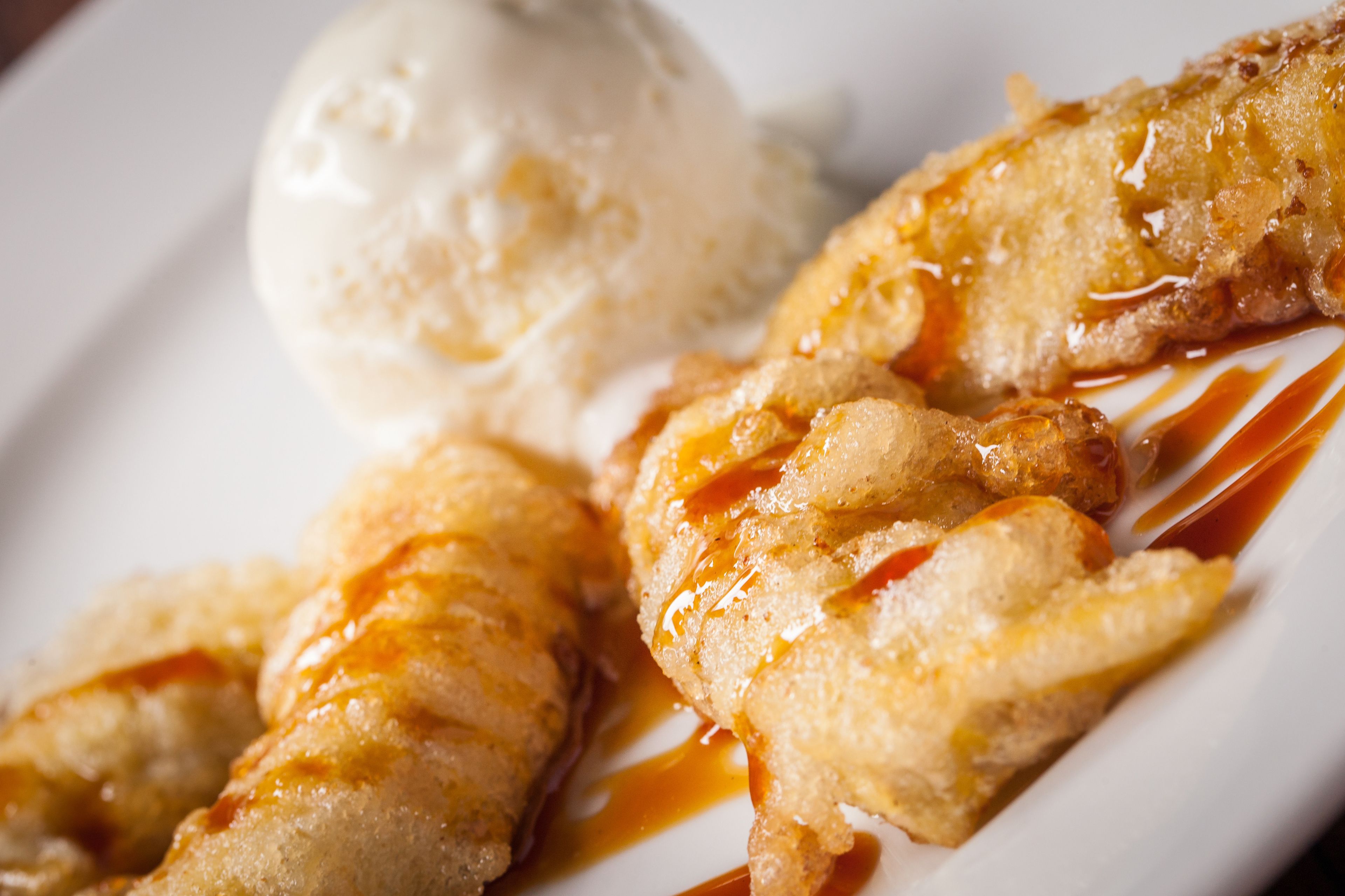 Un piatto con pesce fritto e una pallina di gelato.