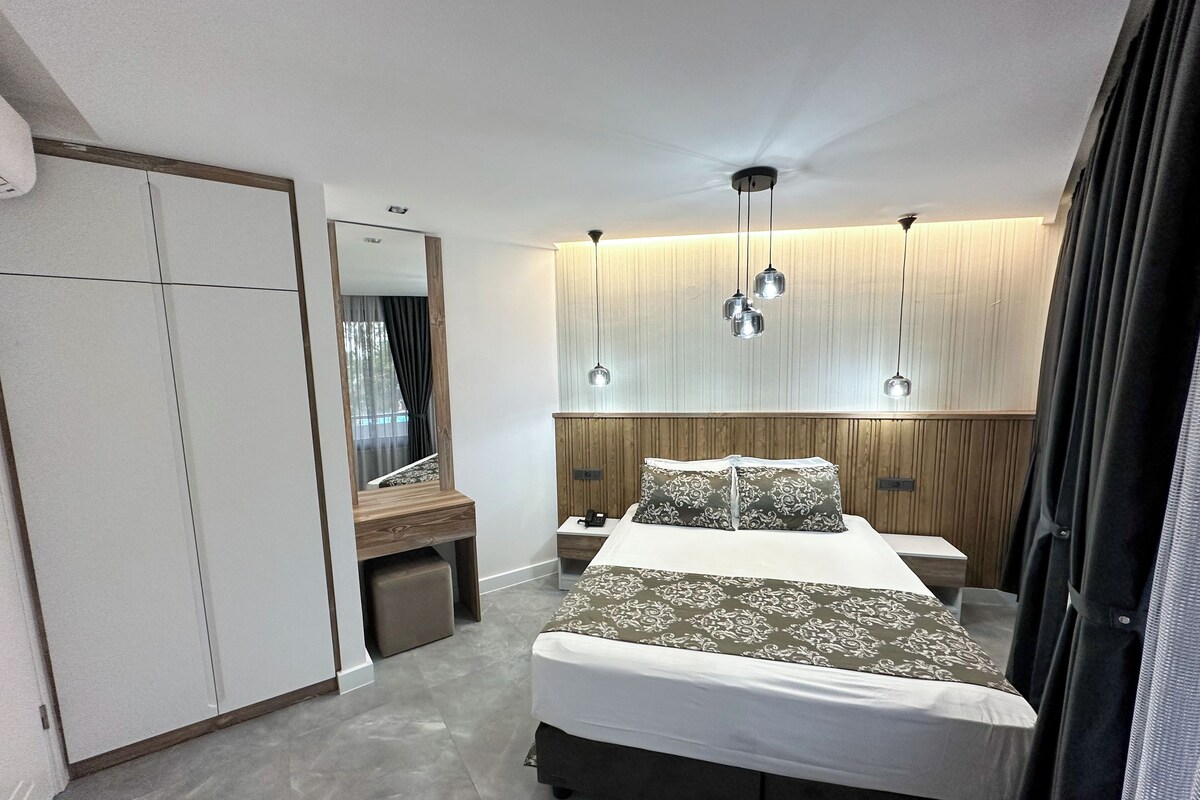 Un dormitorio moderno con cama, mesitas de noche, un espejo y un ventilador de techo.