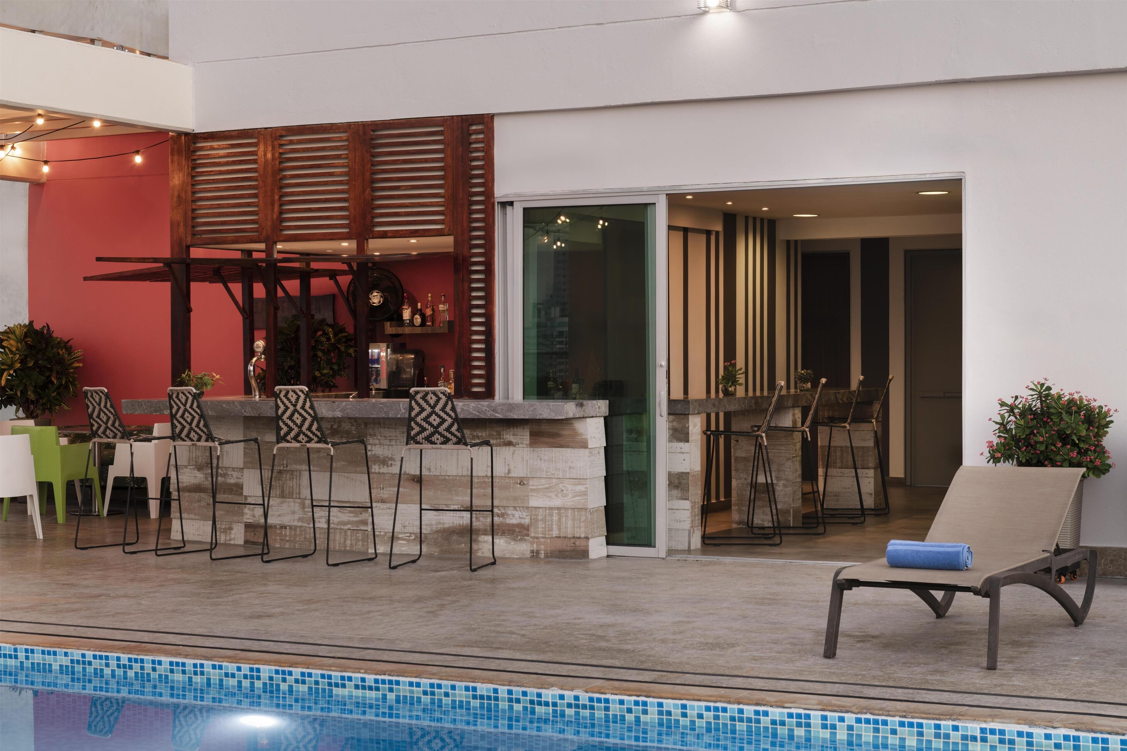 Un área de piscina interior con bar y asientos.