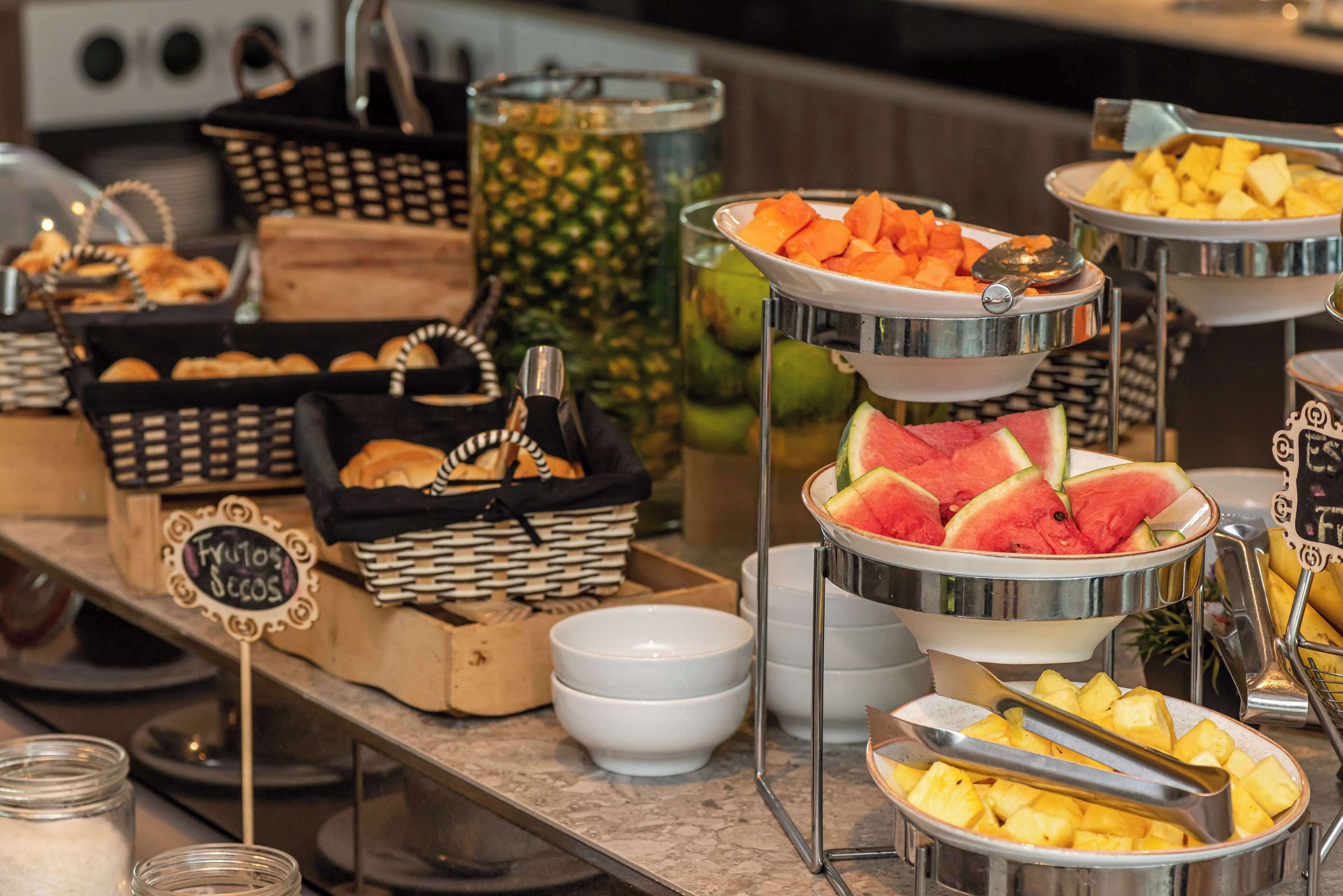 Un bufé con diversas frutas y pasteles.