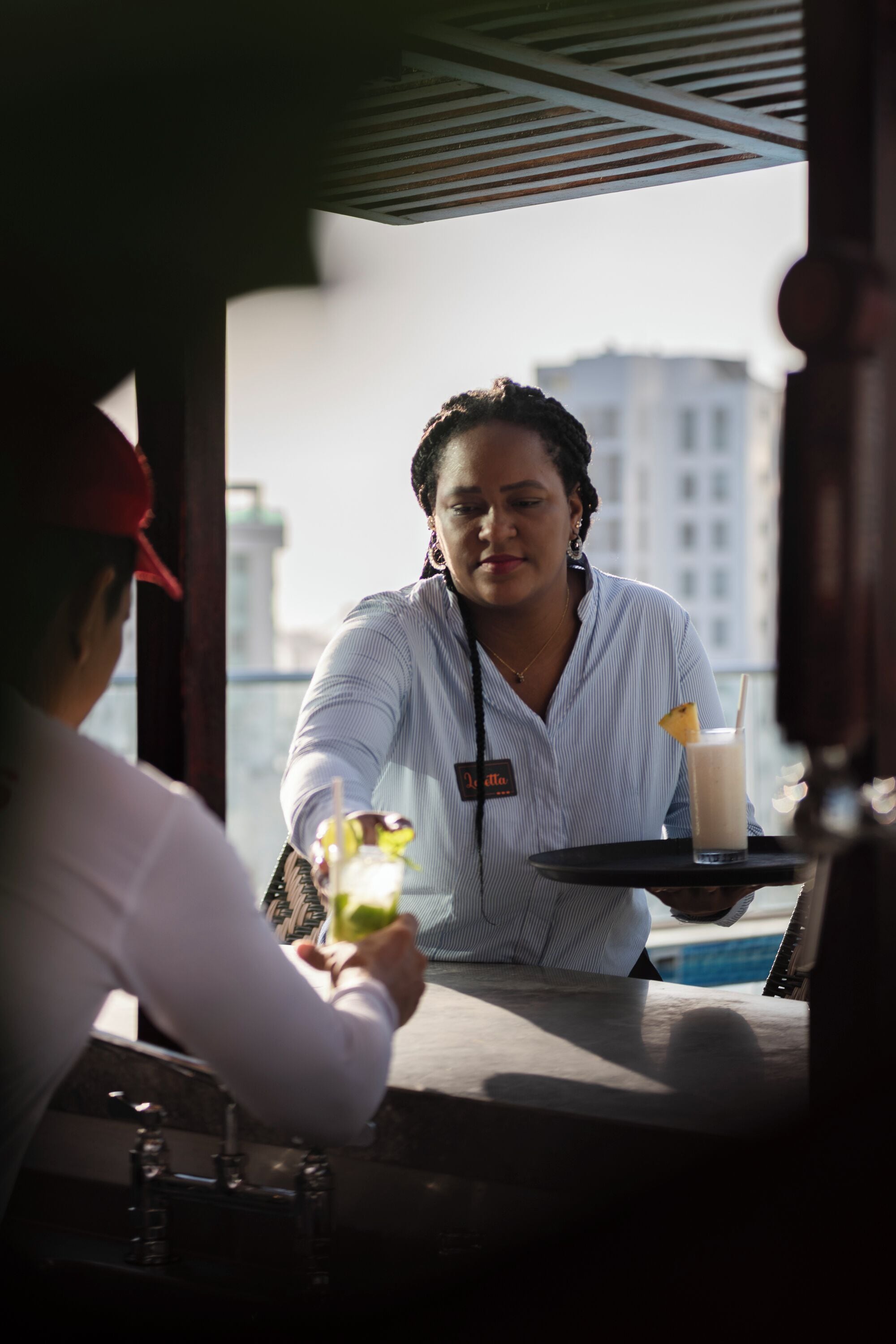 A person at a counter with a drink and a menu.