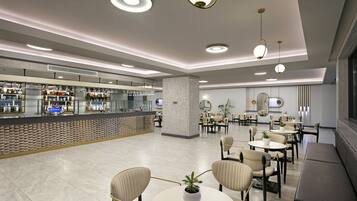 A modern hotel lobby with a bar area, seating arrangements, and a large pillar.