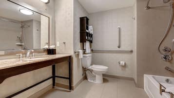 A modern bathroom with a vanity, toilet, shower, and bathtub.