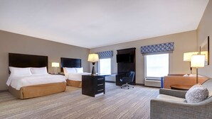 Ein Hotelzimmer mit zwei Betten, einem Schreibtisch, einem Stuhl und einem Fernseher.