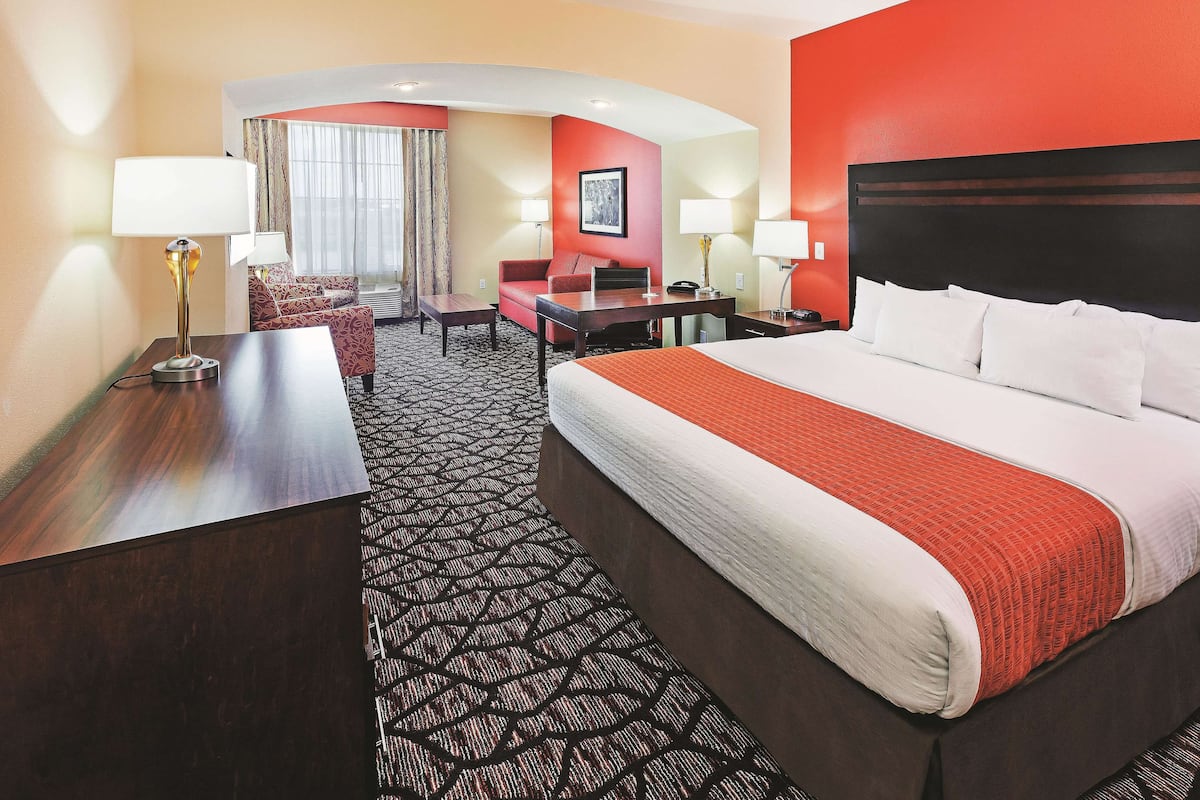 Une chambre d’hôtel avec un grand lit, un bureau, une chaise et un canapé.