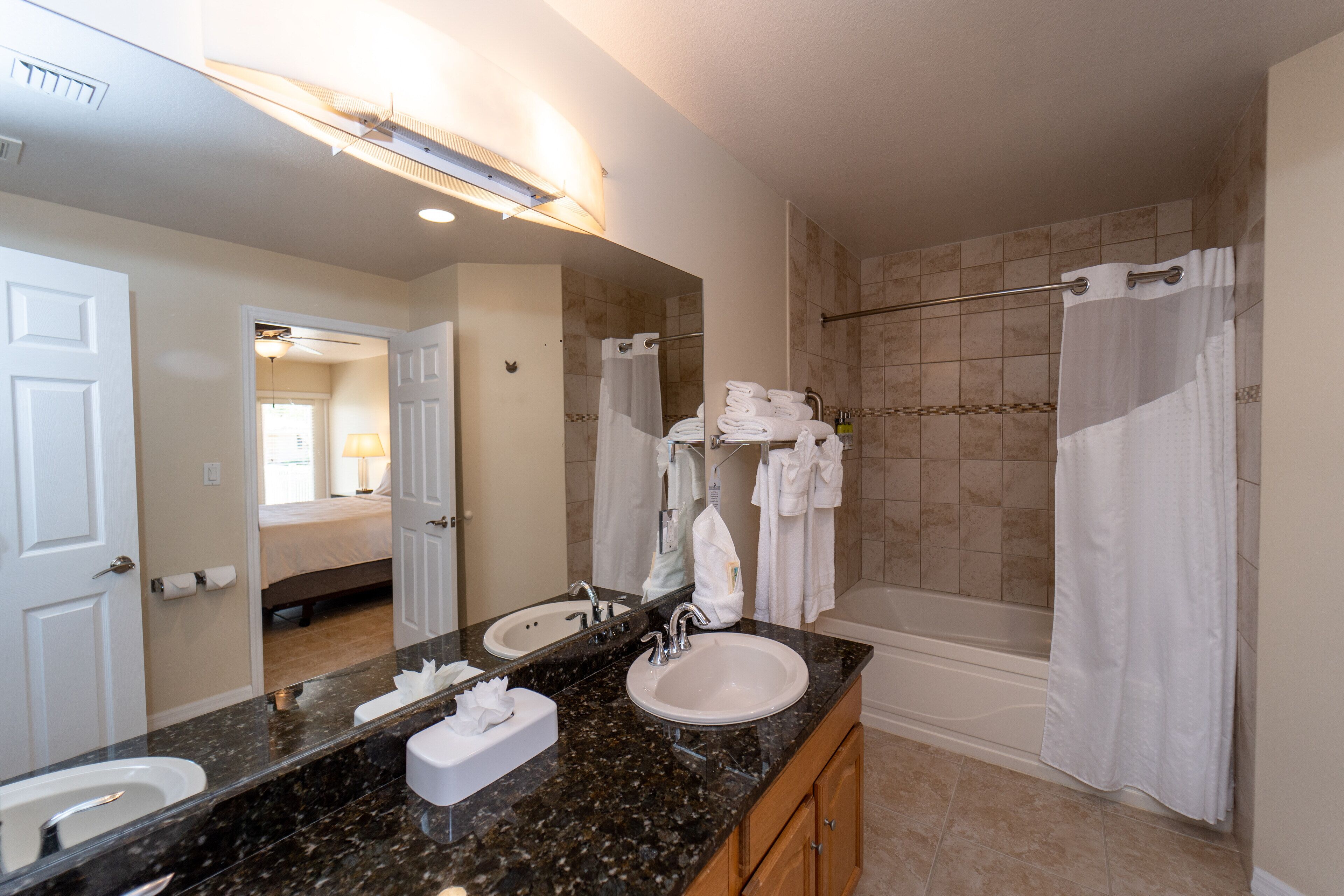 A bathroom with a double sink, a large mirror, a shower, and a bathtub.